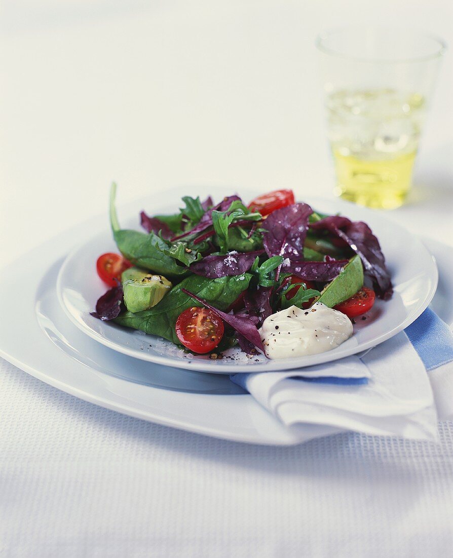 Spinach and avocado salad with cherry tomatoes and sour cream