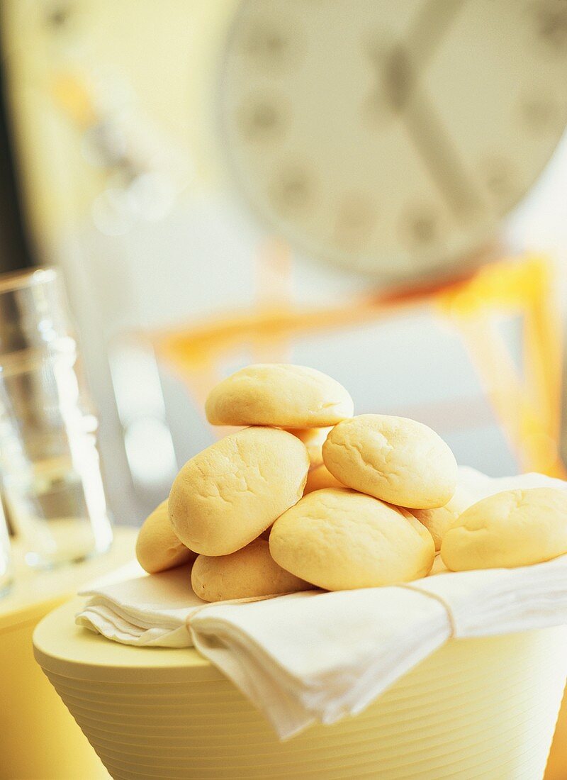 Bread rolls on white cloth in kitchen