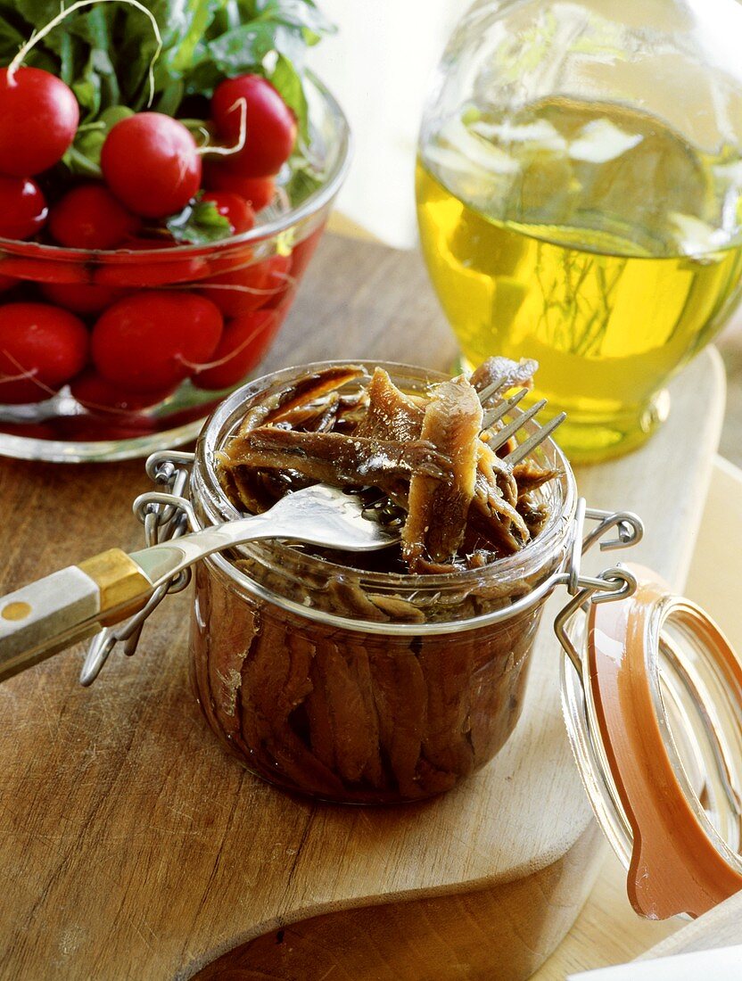 Eingelegte Sardellen im Glas; Radieschen; Olivenöl