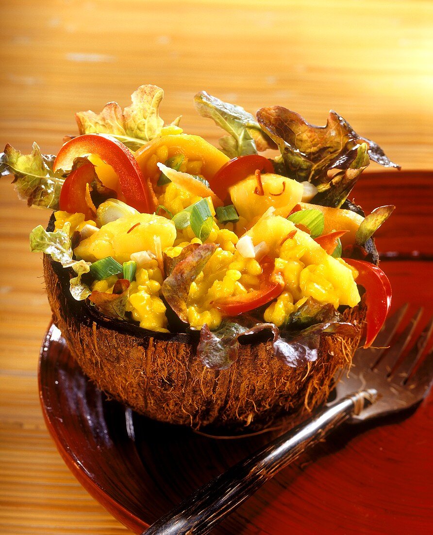 Exotischer Reissalat mit Früchten und Gemüse in Kokosnuss