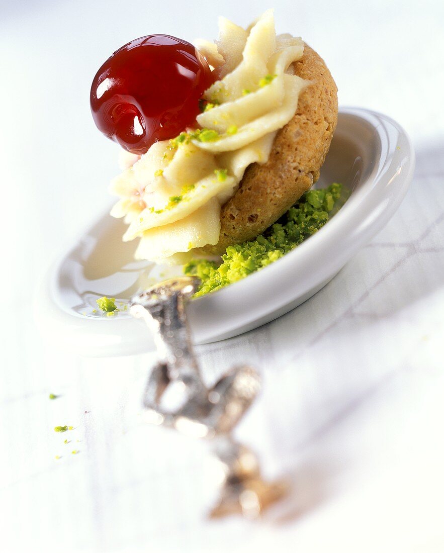Biscuit with pistachio cream and cocktail cherry
