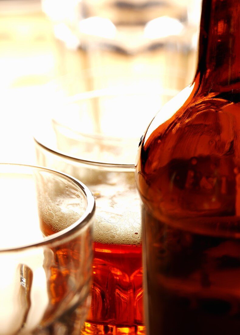 A glass of ale with beer bottle