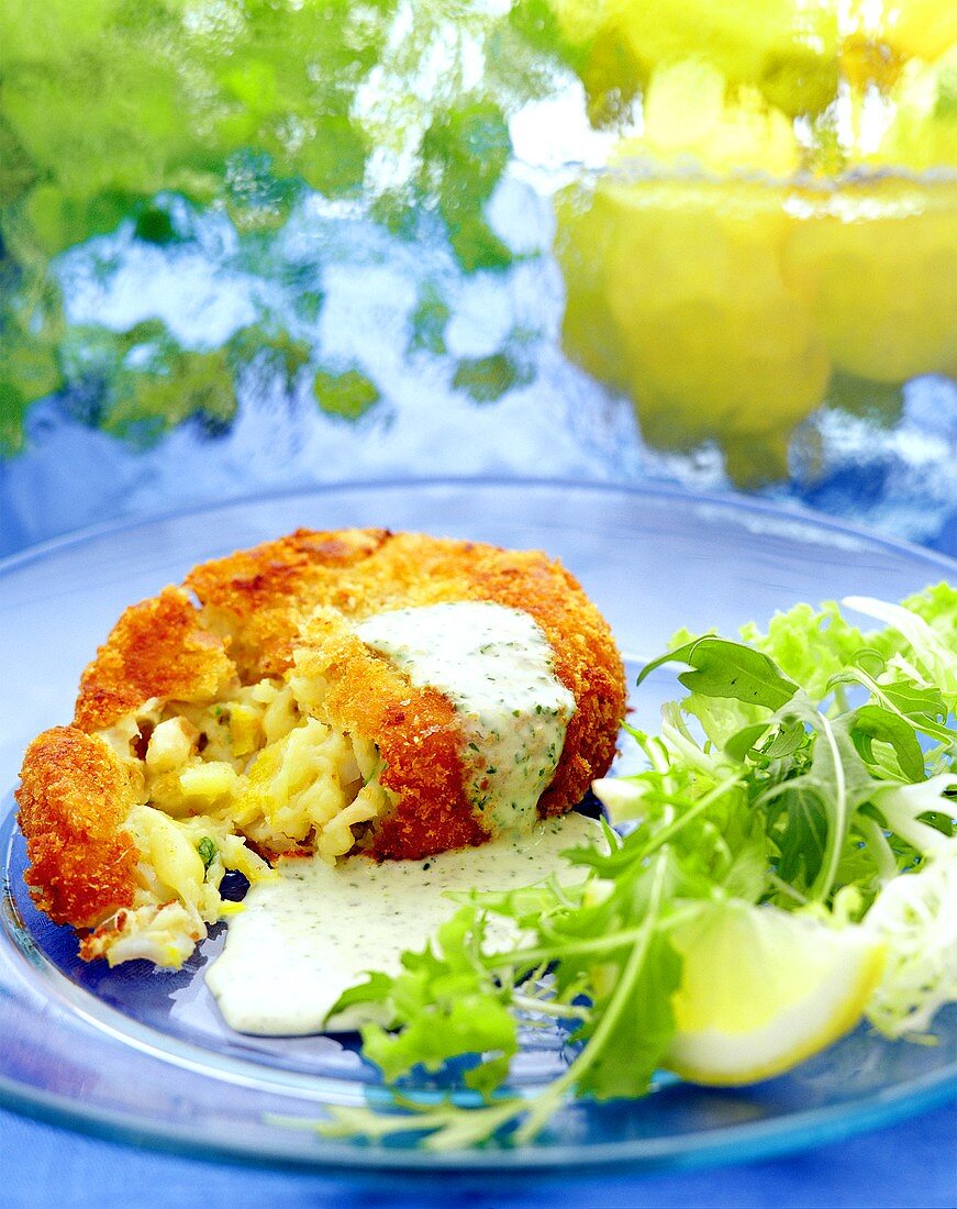 Fish cake with herb sauce, lettuce and lemon