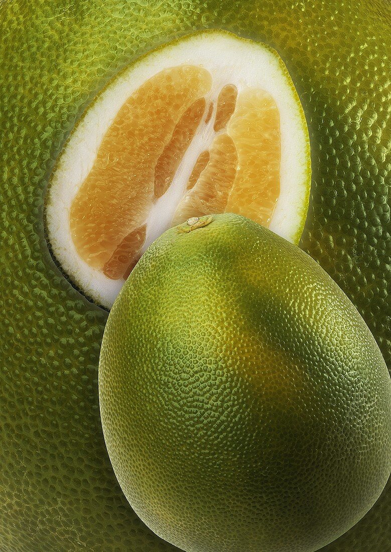 Whole and half pomelo on background of pomelos