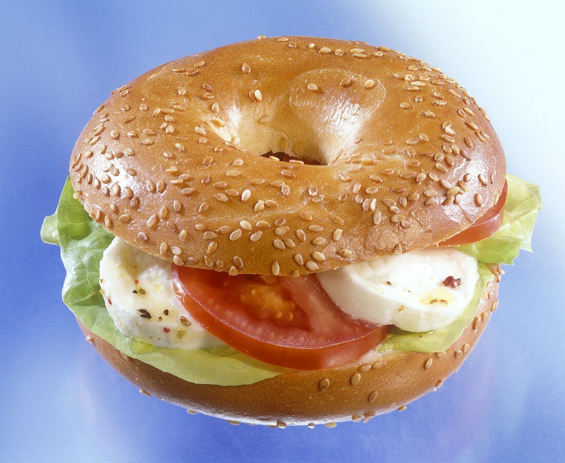 Sesame bagel with mozzarella and tomatoes