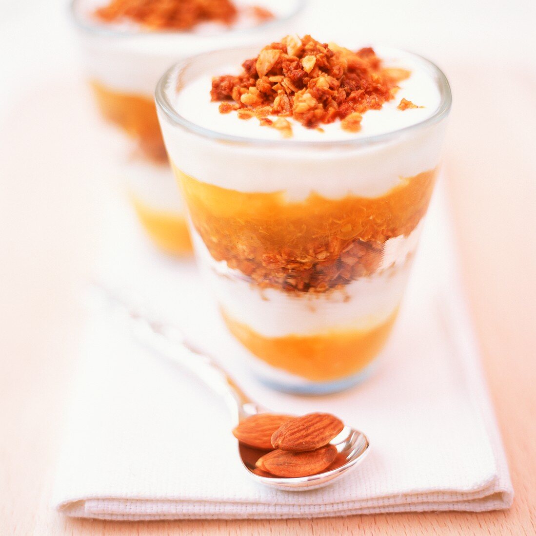 Layered sundae with yoghurt, almonds and mango sauce