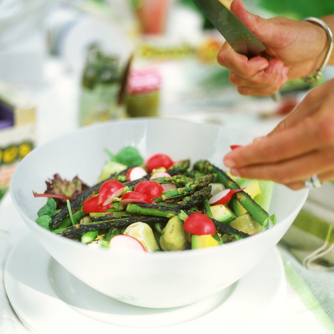 Making asparagus and artichoke salad with radishes