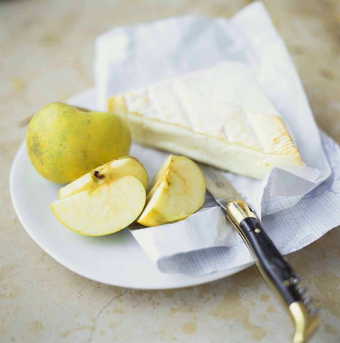 Camembert and green apple on plate