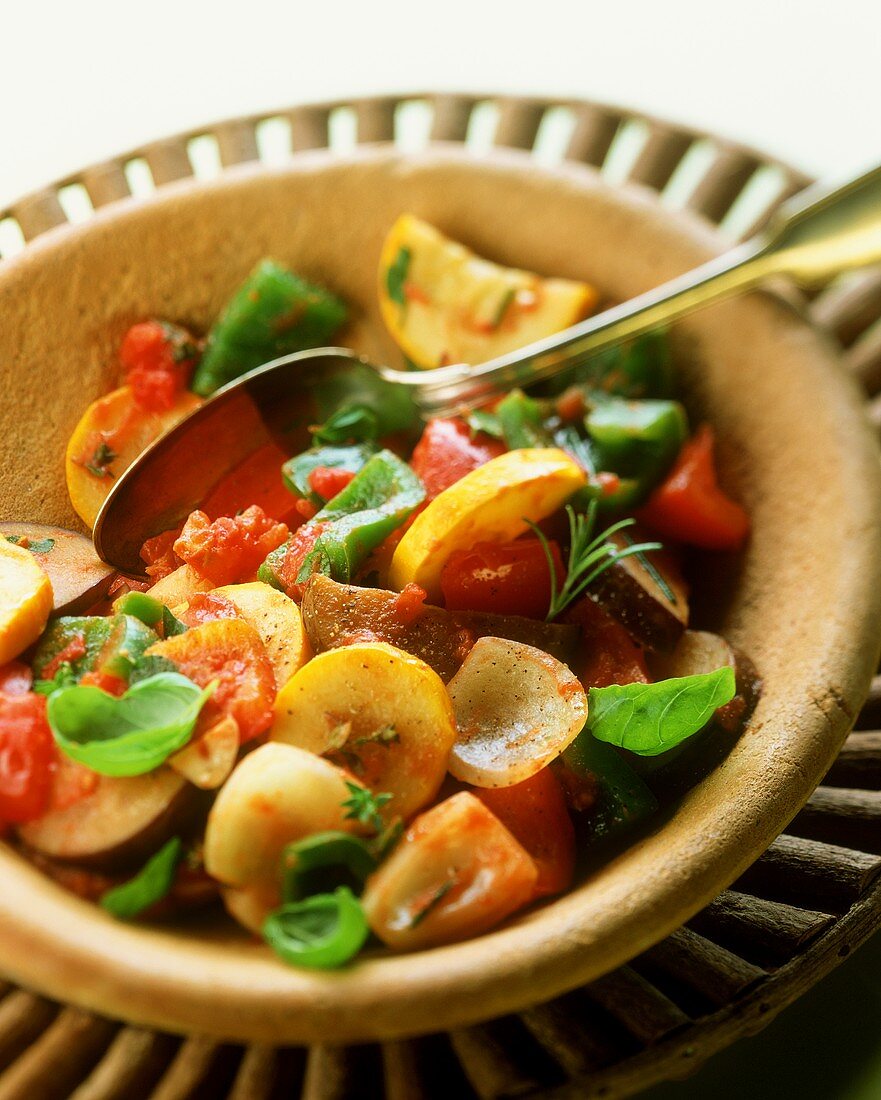 Vegetable stew with basil in terracotta plate