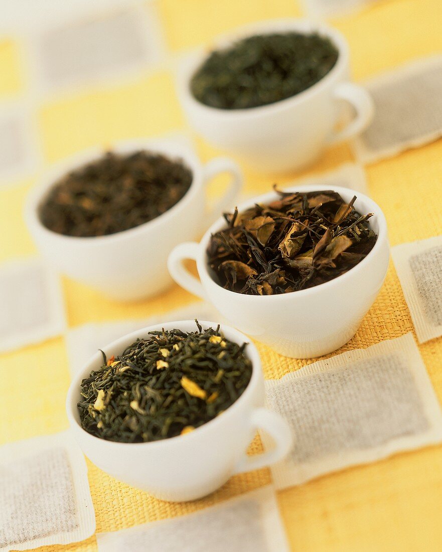 Verschiedene Teesorten in Tassen und Teebeuteln