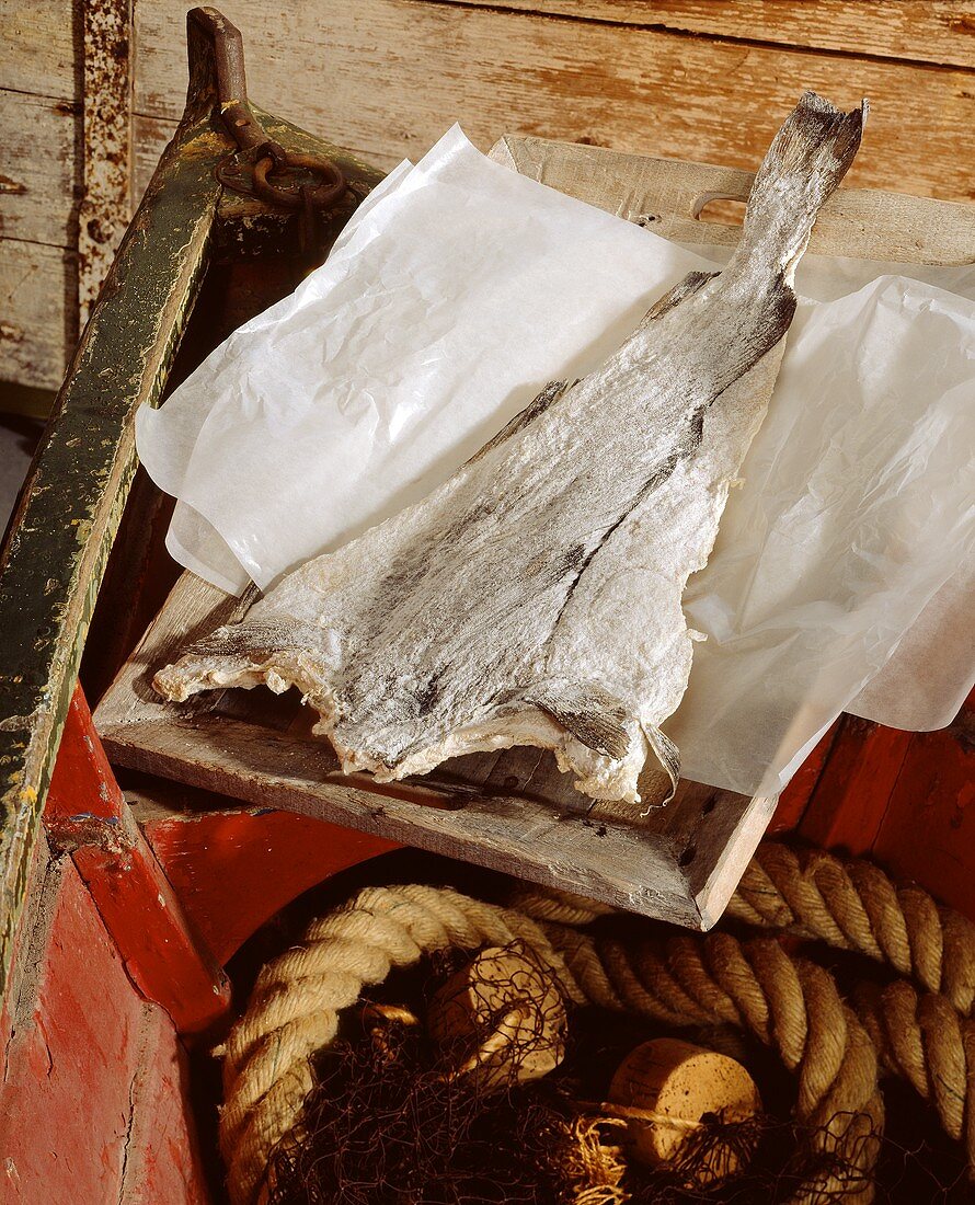 Stockfish in old boat on greaseproof paper