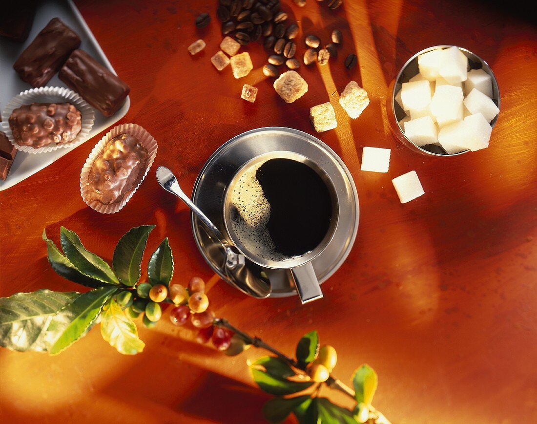 Coffee cup from above, sugar, coffee beans and chocolates