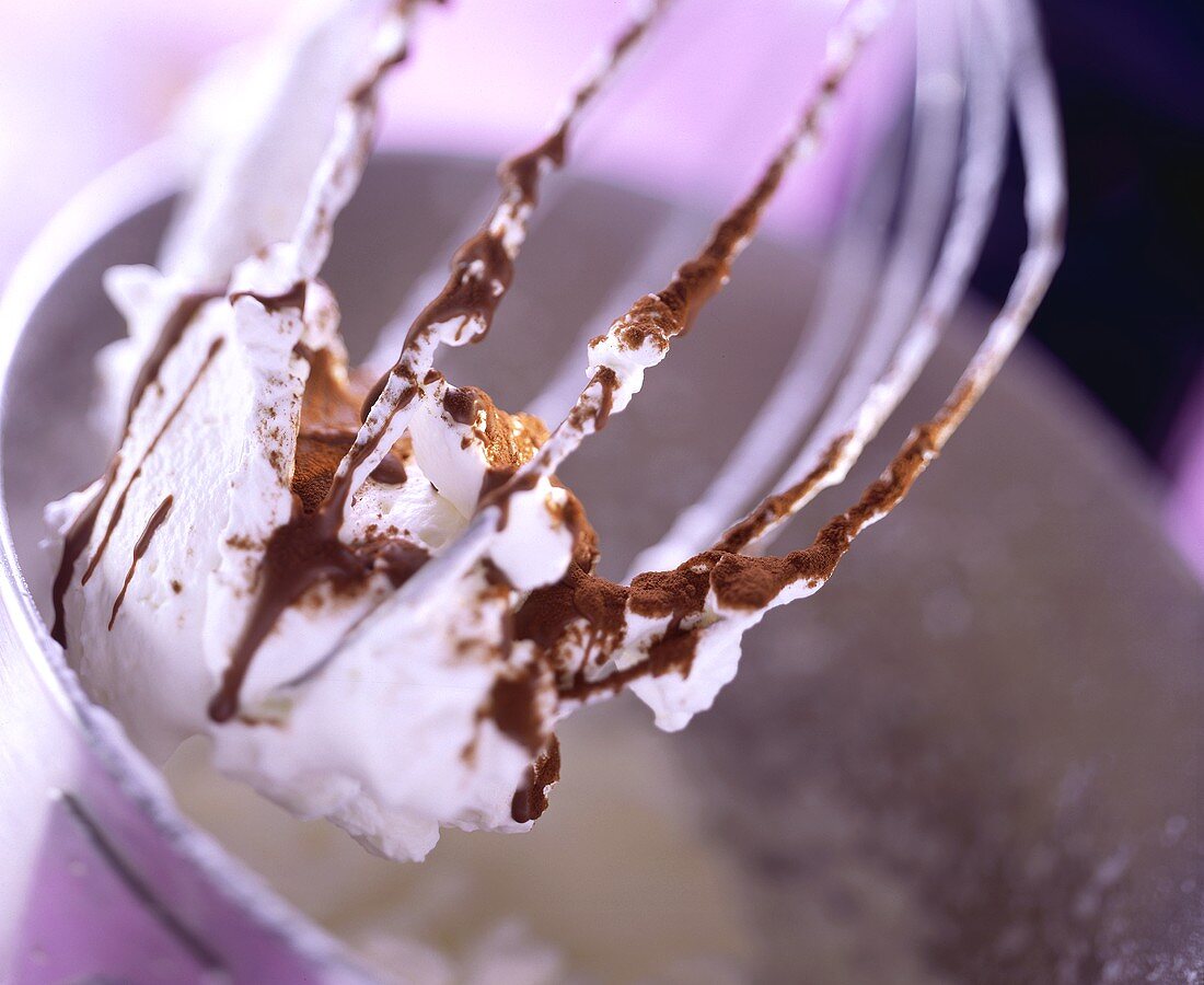 Eischnee mit Kakaopulver und Schokoladensauce auf Schneebesen