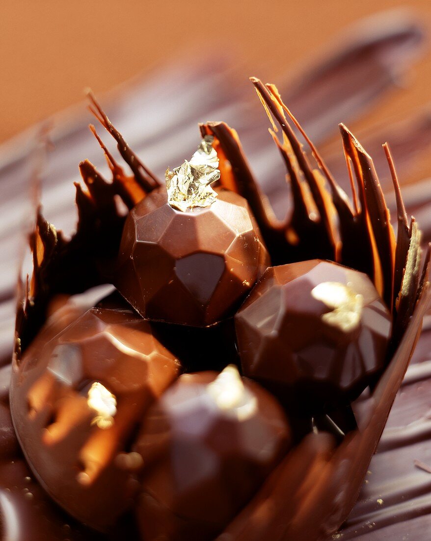 Diamond-shaped filled chocolates with gold leaf