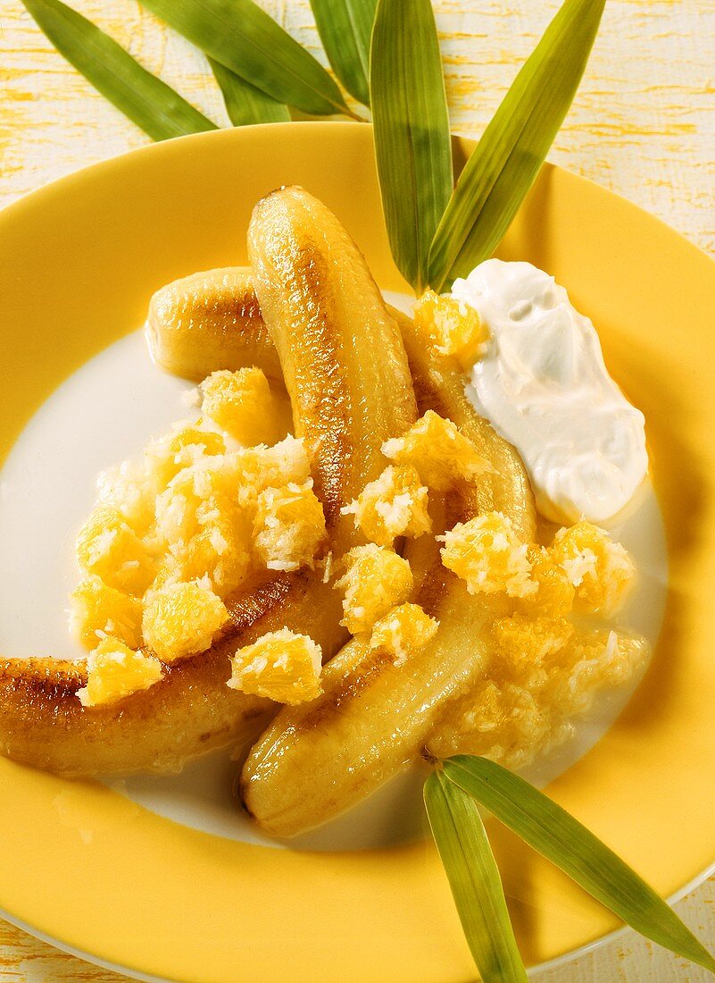 Fried bananas with coconut, oranges and cream