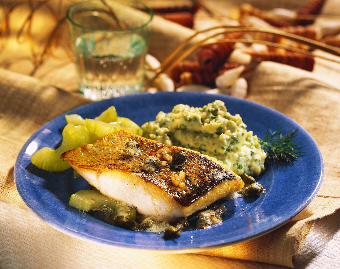 Fish with herb mashed potato, capers and braised cucumber