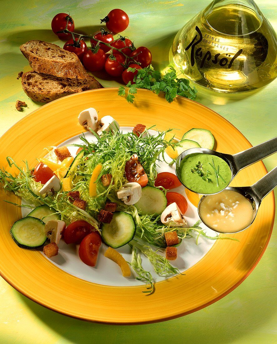 Friseesalat mit Gemüse, Croûtons und zwei Salatsaucen; Rapsöl