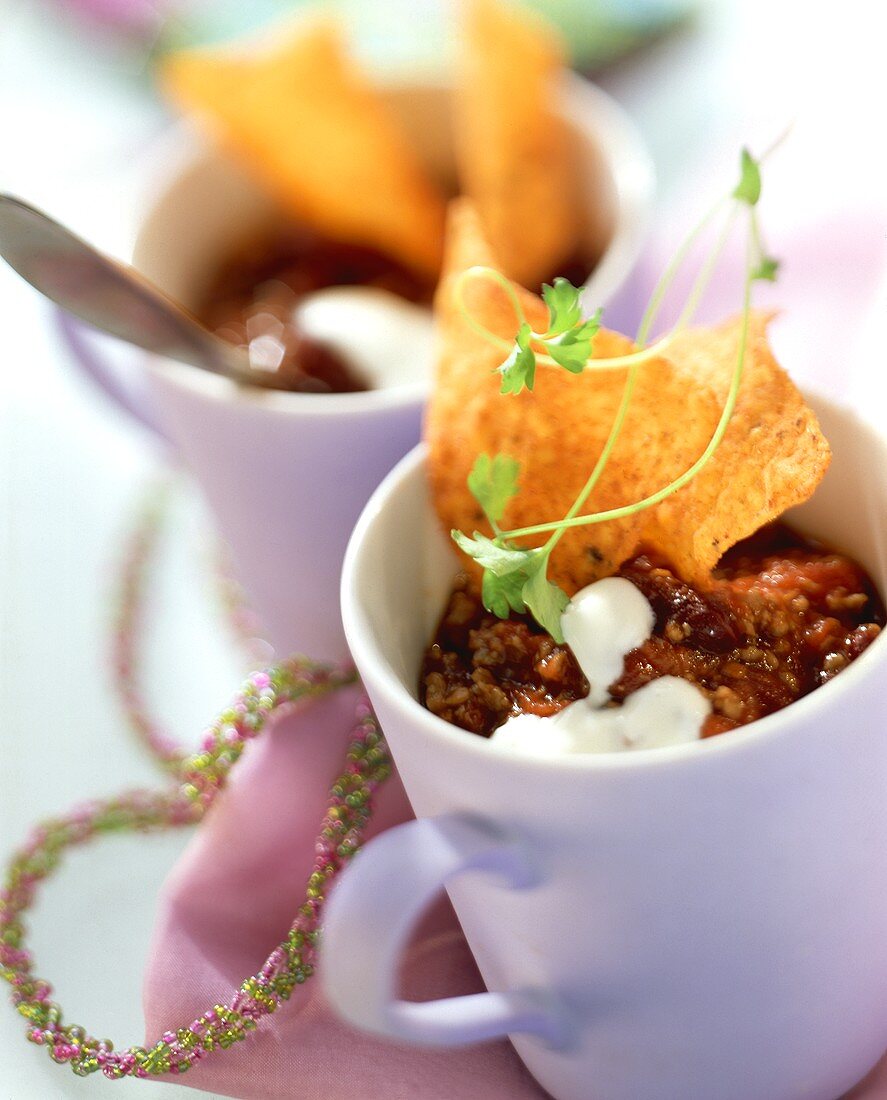 Chili con Carne mit saurer Sahne, Chips und Petersilie