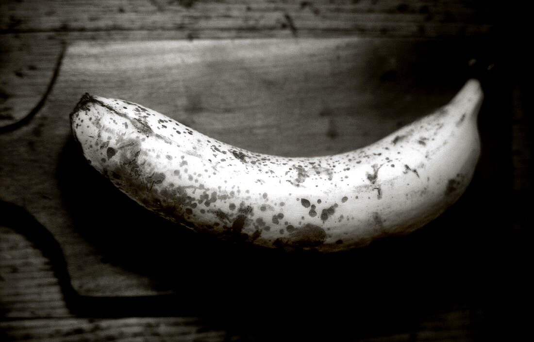 Over-ripe banana on wooden chopping board