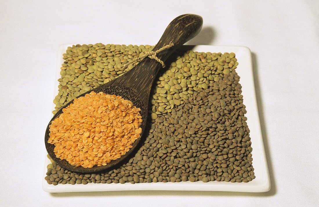 Red, brown and green lentils in bowl and spoon
