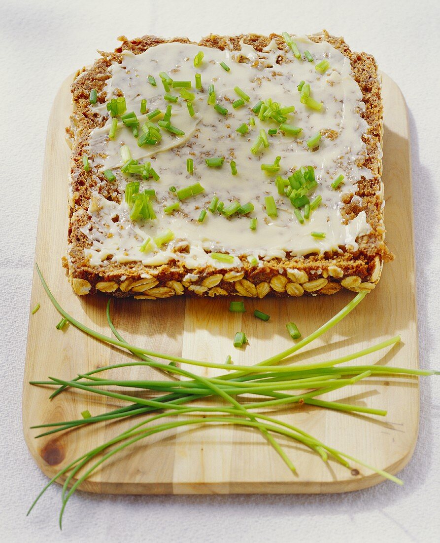 Butterbrot mit Schnittlauch auf Schneidebrett