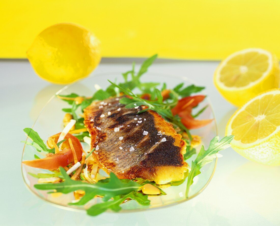 Fried sea bass on strips of vegetables with rocket