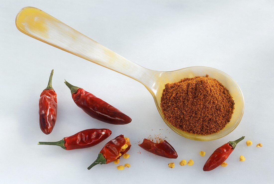 Chili powder on spoon and dried chili peppers