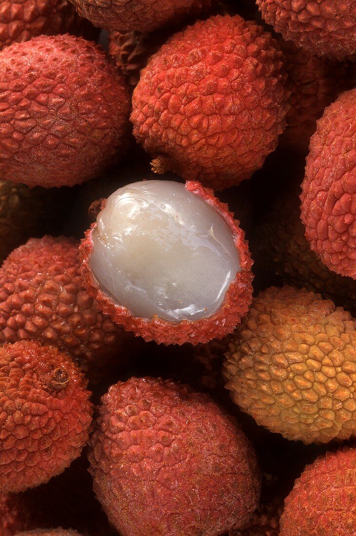 Lychees, eine halb geschält (bildfüllend)