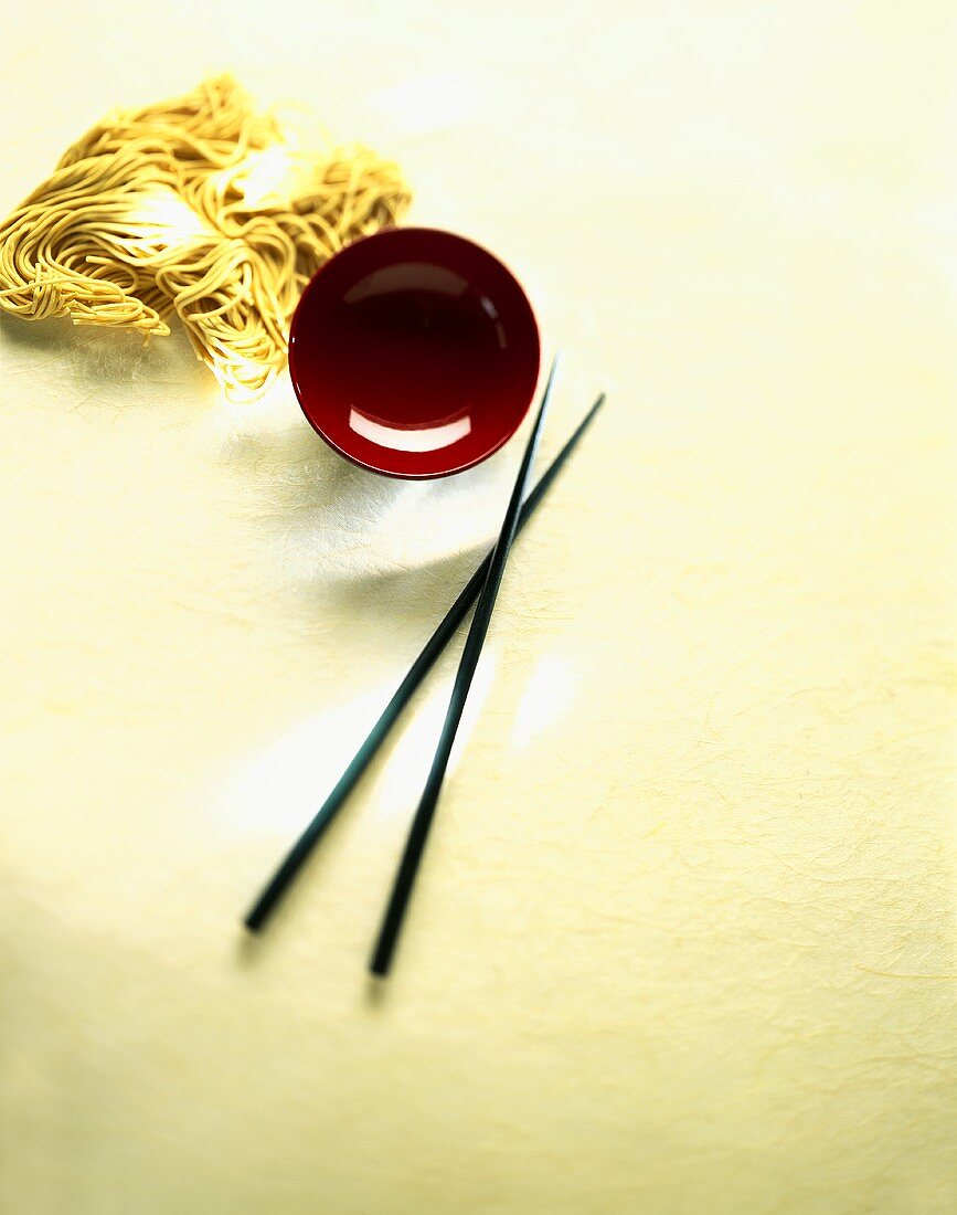 Asian noodles, red lacquer bowl and chopsticks