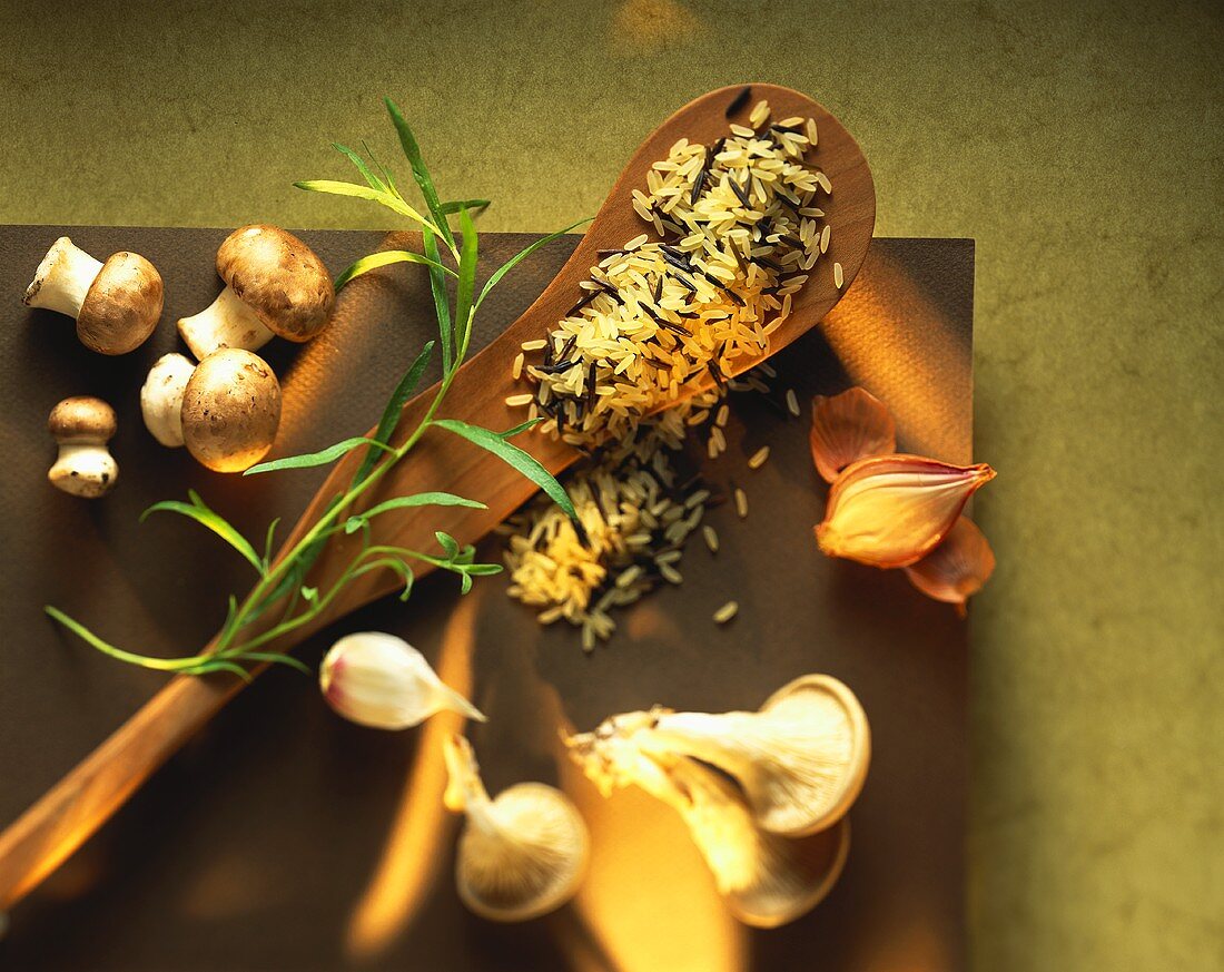 Rice on wooden spoon; mushrooms; tarragon; garlic