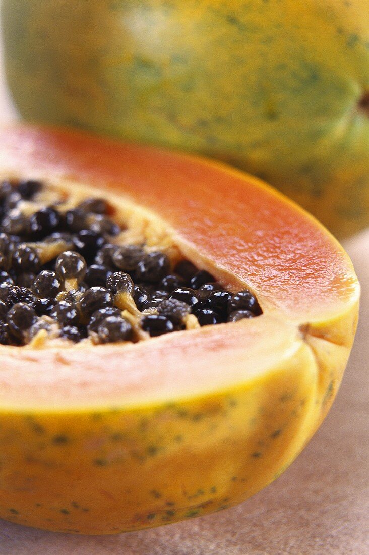 Papayas, one halved (close-up)
