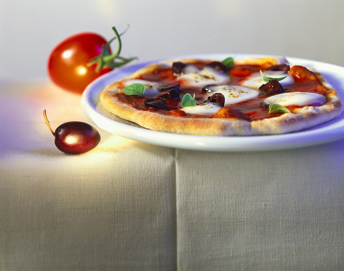 Pizza with tomatoes, olives and mozzarella