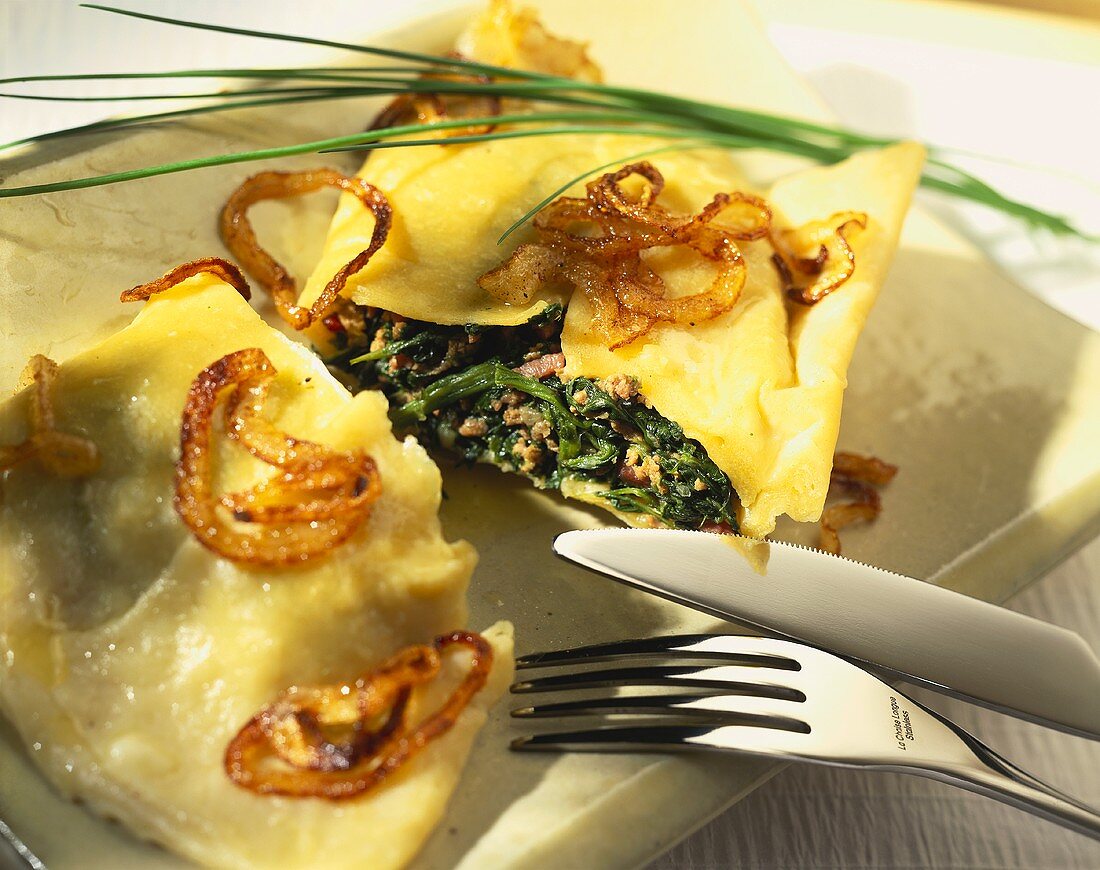 Spinach-filled pasta envelopes with onions