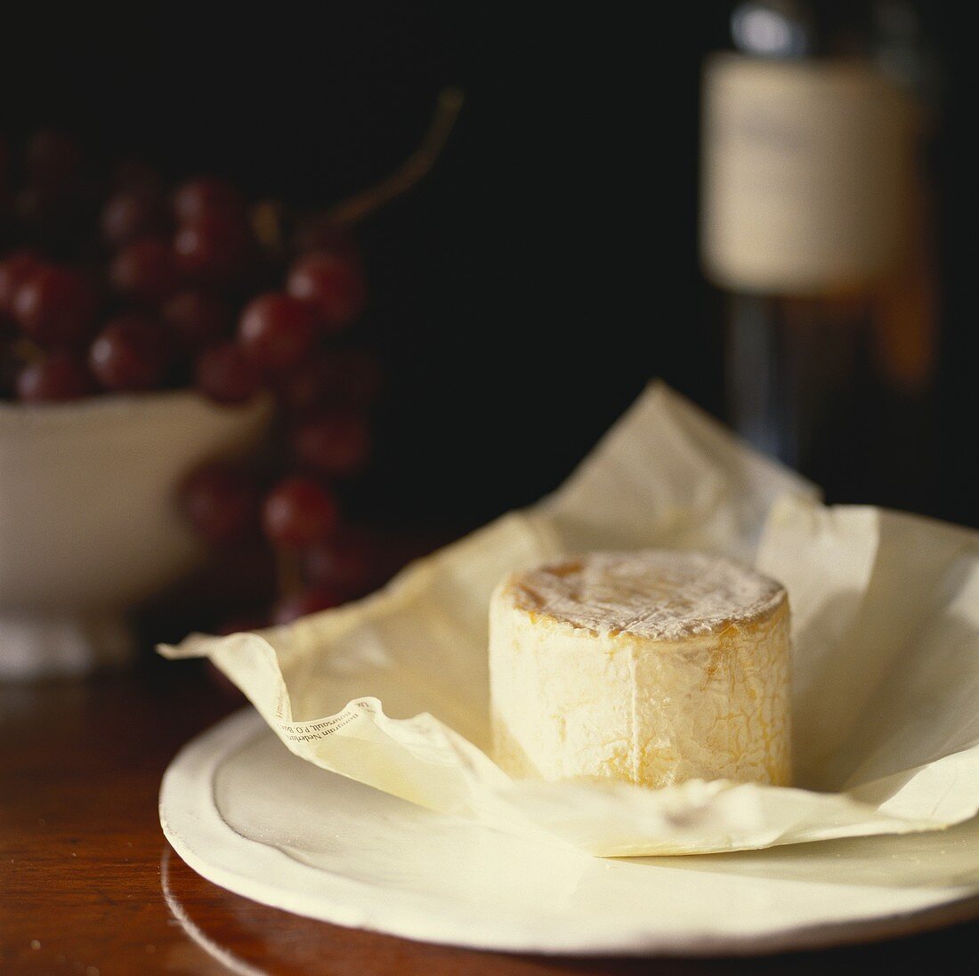 English goat's cheese on paper; red grapes