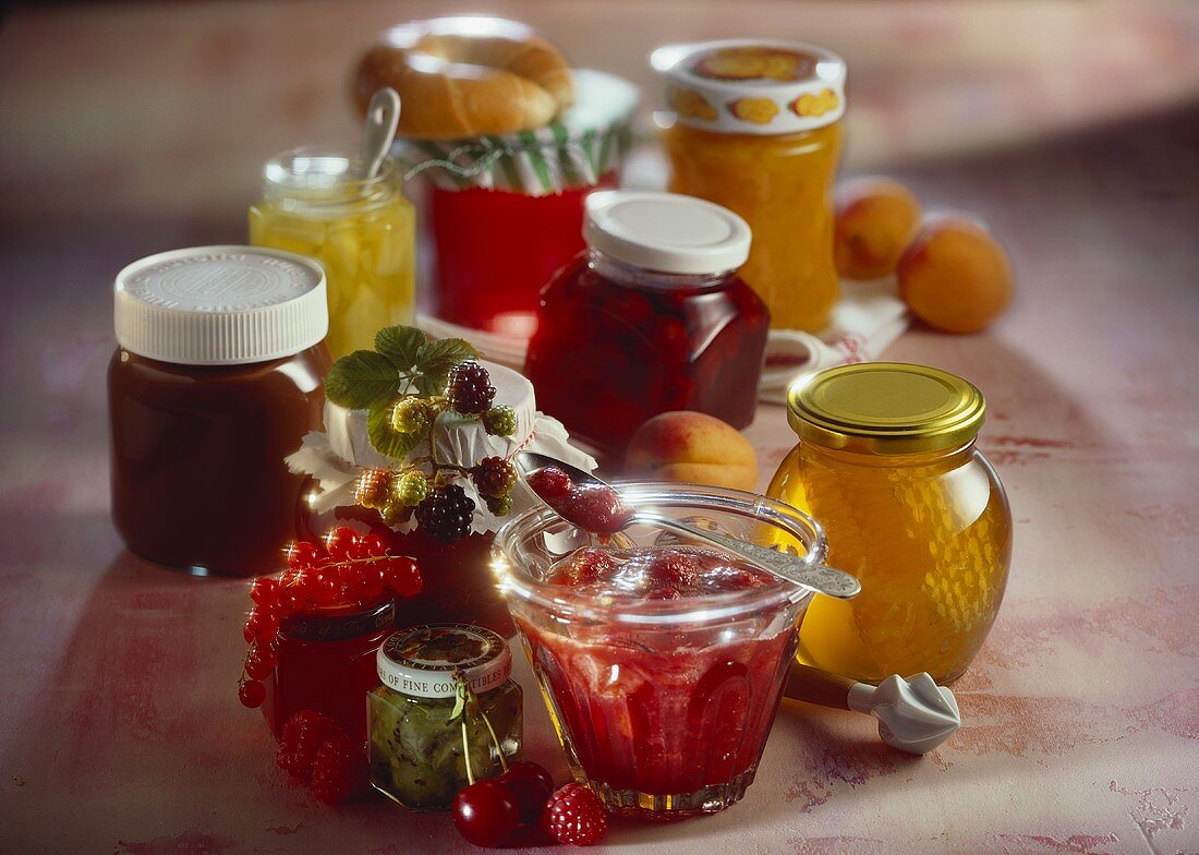 Verschiedene Marmeladengläser, Honig und Nutella