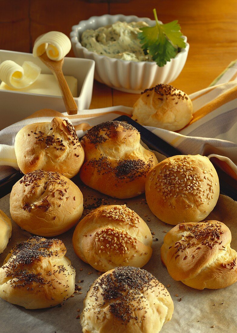 Freshly baked rolls with poppy seeds, sesame & caraway; butter