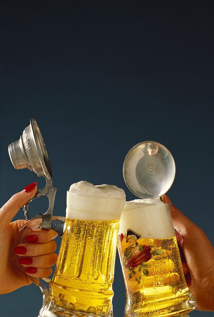 Hands drinking a toast with beer tankards