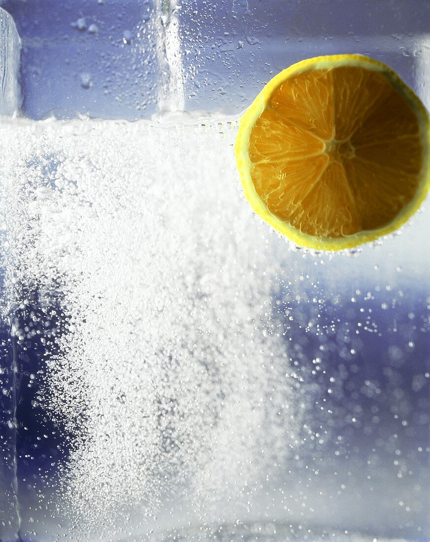 Sprudelndes Mineralwasser mit Zitronenscheibe
