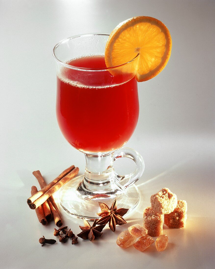 Glass of punch with lemon, spices and sugar