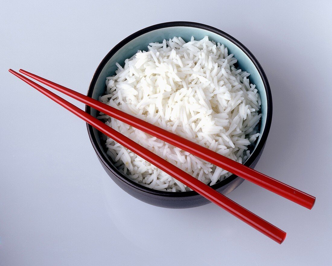 Schale Reis mit roten Stäbchen