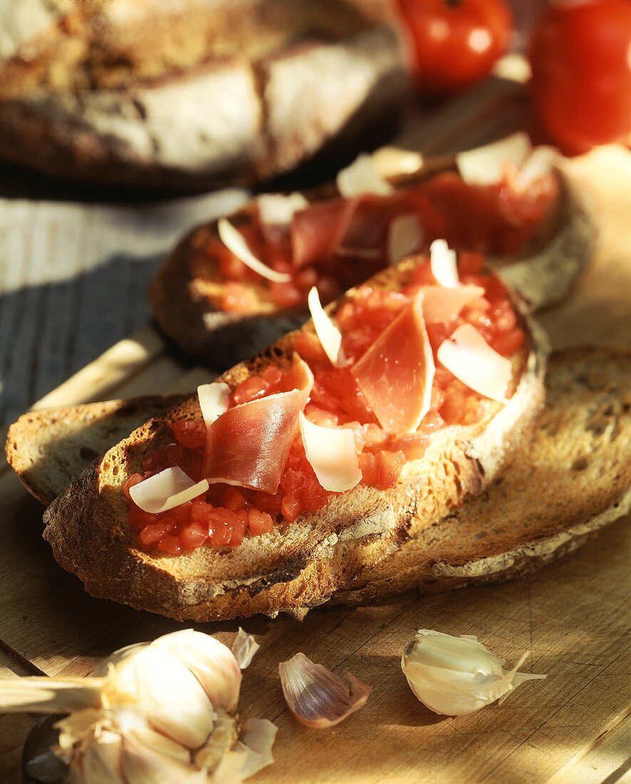 Geröstetes Knoblauchbrot mit Tomaten und Schinken