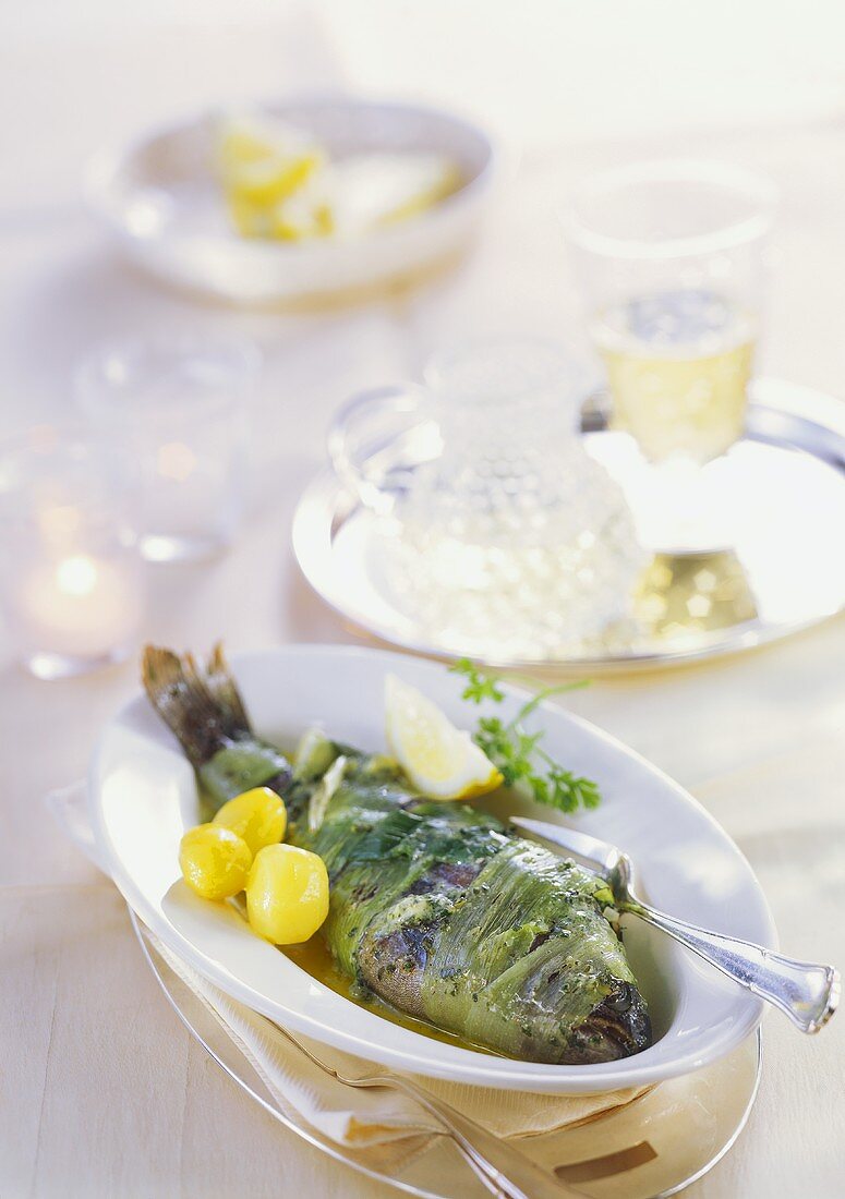 Stuffed trout wrapped in leeks with lemon and herb butter