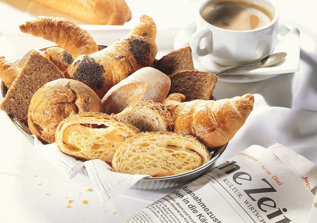 Bread basket with coffee and newspaper