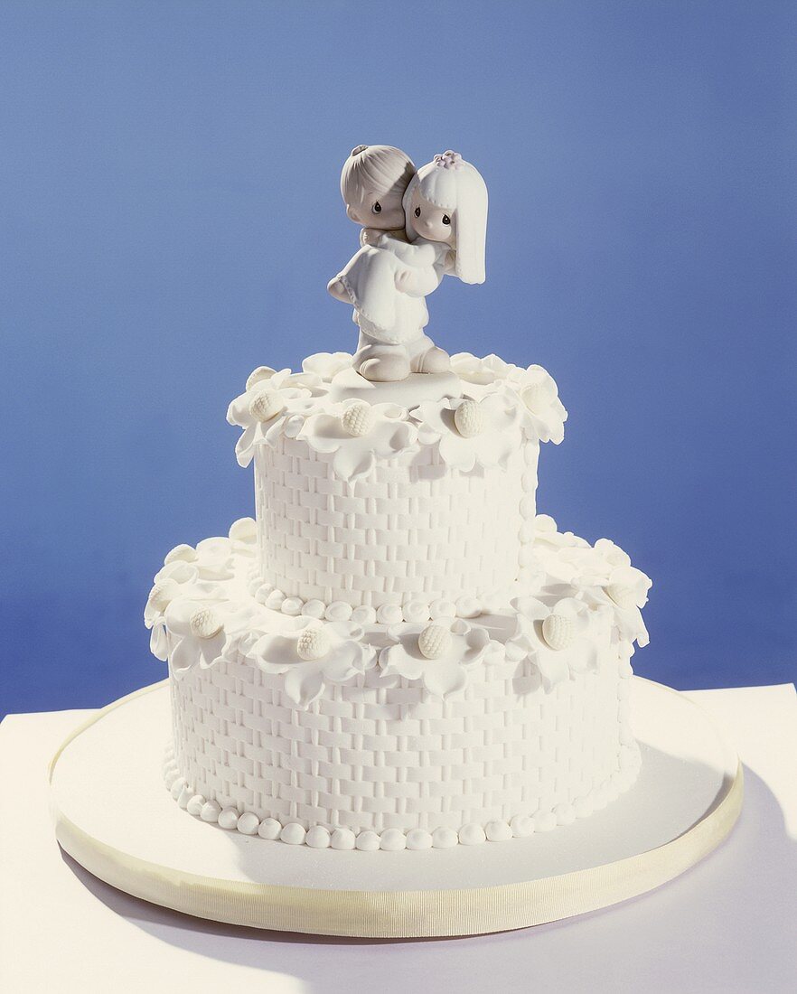 White two-tiered wedding cake with bride and groom figures