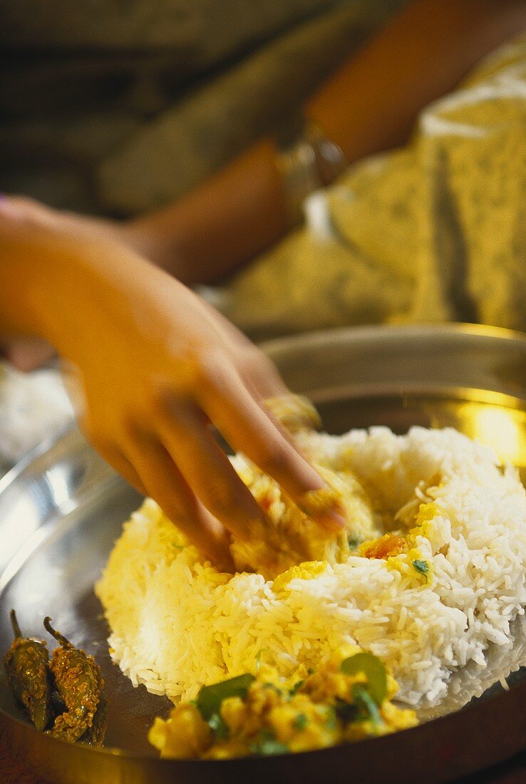 Indian woman eating rice with her fingers