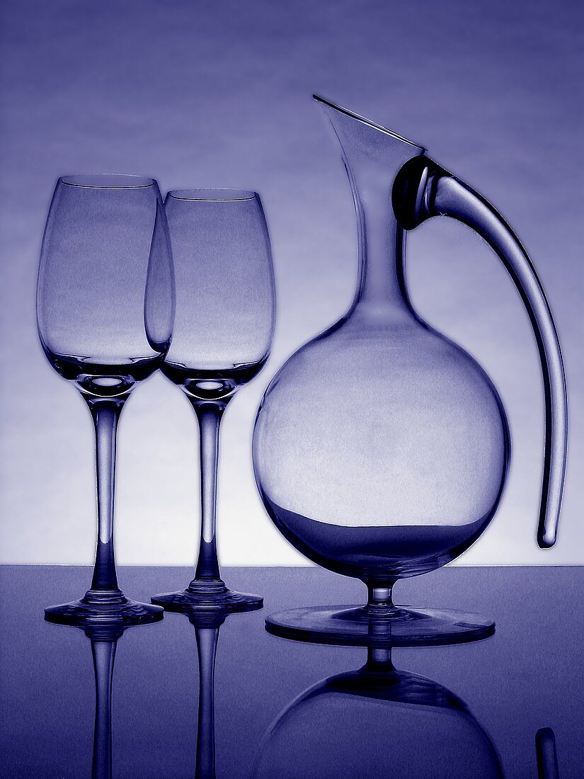 Zwei leere Weingläser und eine Karaffe (blau getönt)
