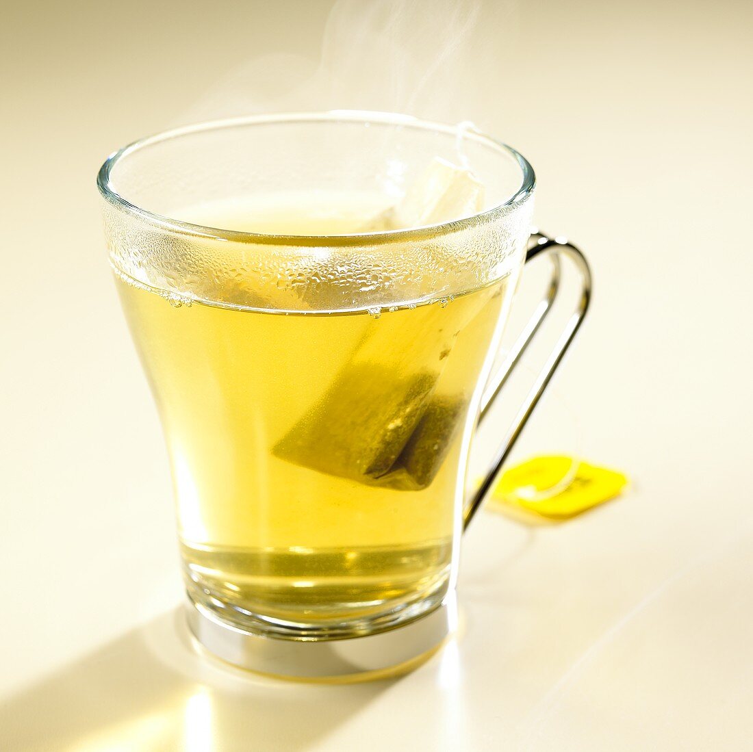 Green tea with lemon with tea bag in glass