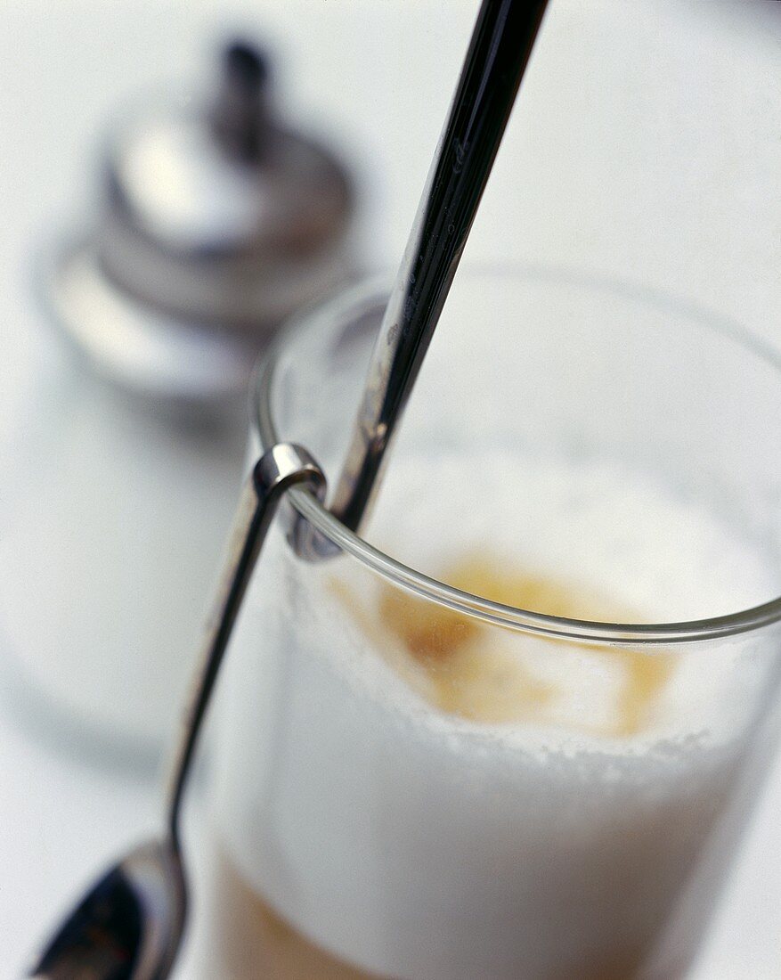 Latte Macchiato im Glas mit Löffel