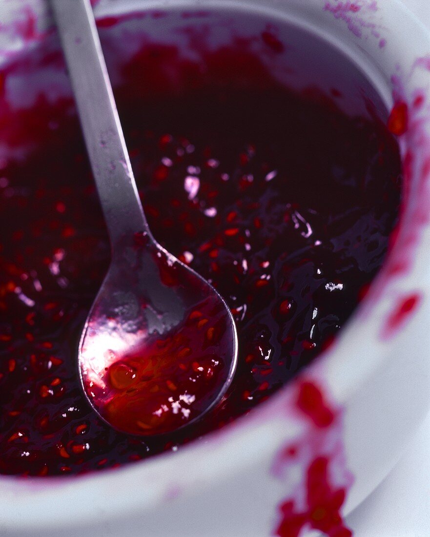 Raspberry jam in bowl with spoon