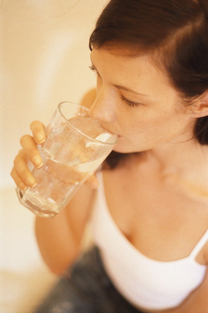 Junge Frau trinkt Glas Wasser